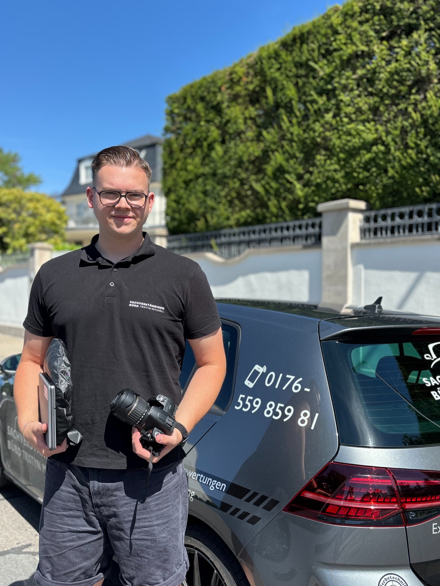 Tristyn Mitchell mit Kamera vor seinem Fahrzeug